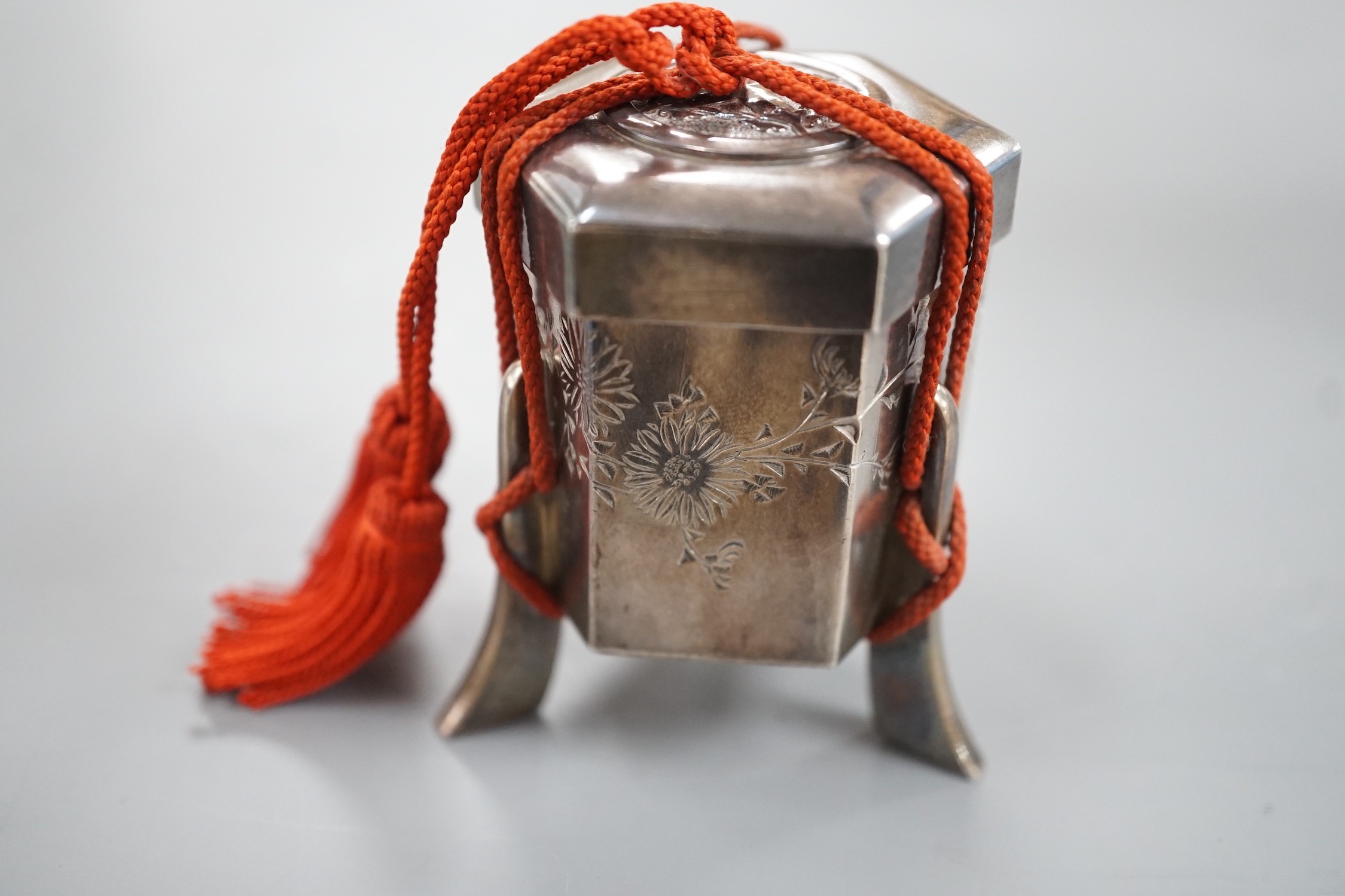 An early 20th century Japanese white metal hexagonal box and cover, signed to the base, height 53mm, gross weight 74 grams.